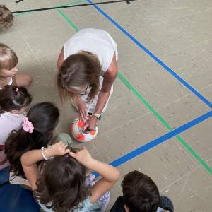 Lehrerin beschriftet Ball mit Wünschen